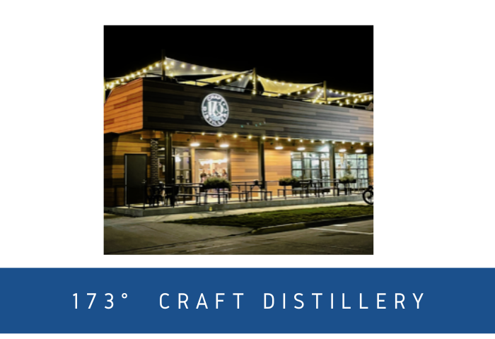 Exterior photo of 173° Craft Distillery at night with rooftop lights and outdoor patio seating.