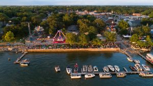 Aerial view of downtown Clear Lake, Iowa during the July 4 celebration with carnival rides in City Park and boats along the lakefront.